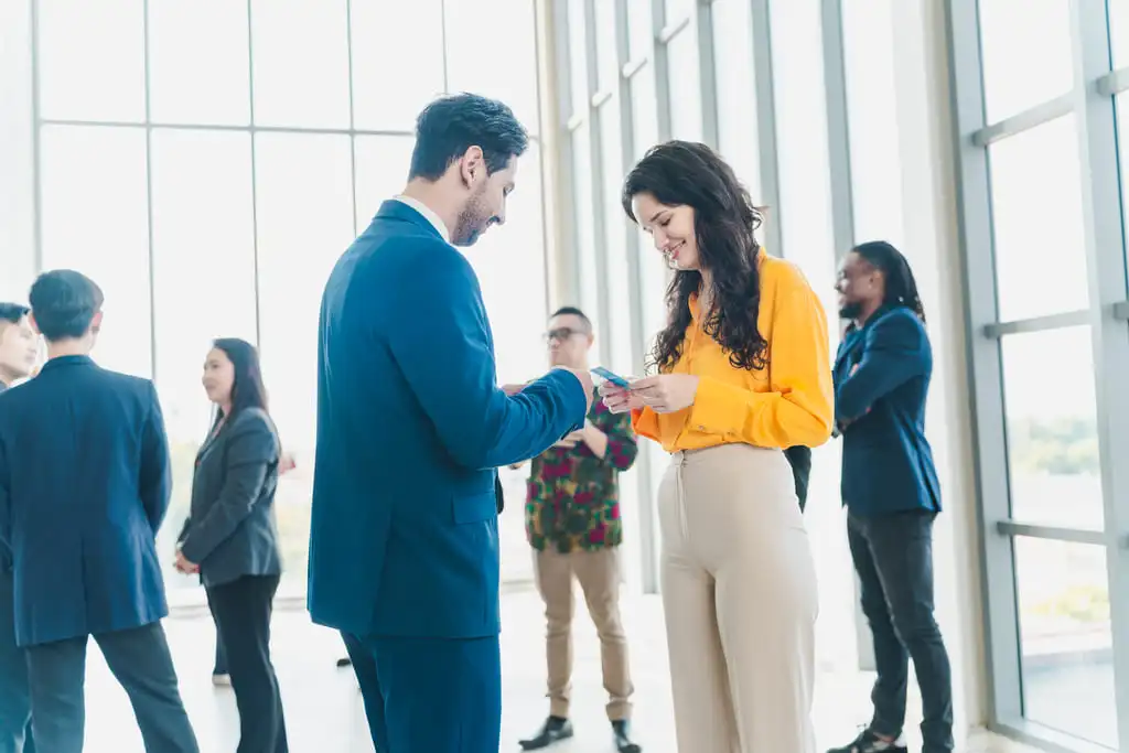woman receiving a business card on a business meeting from a businessman